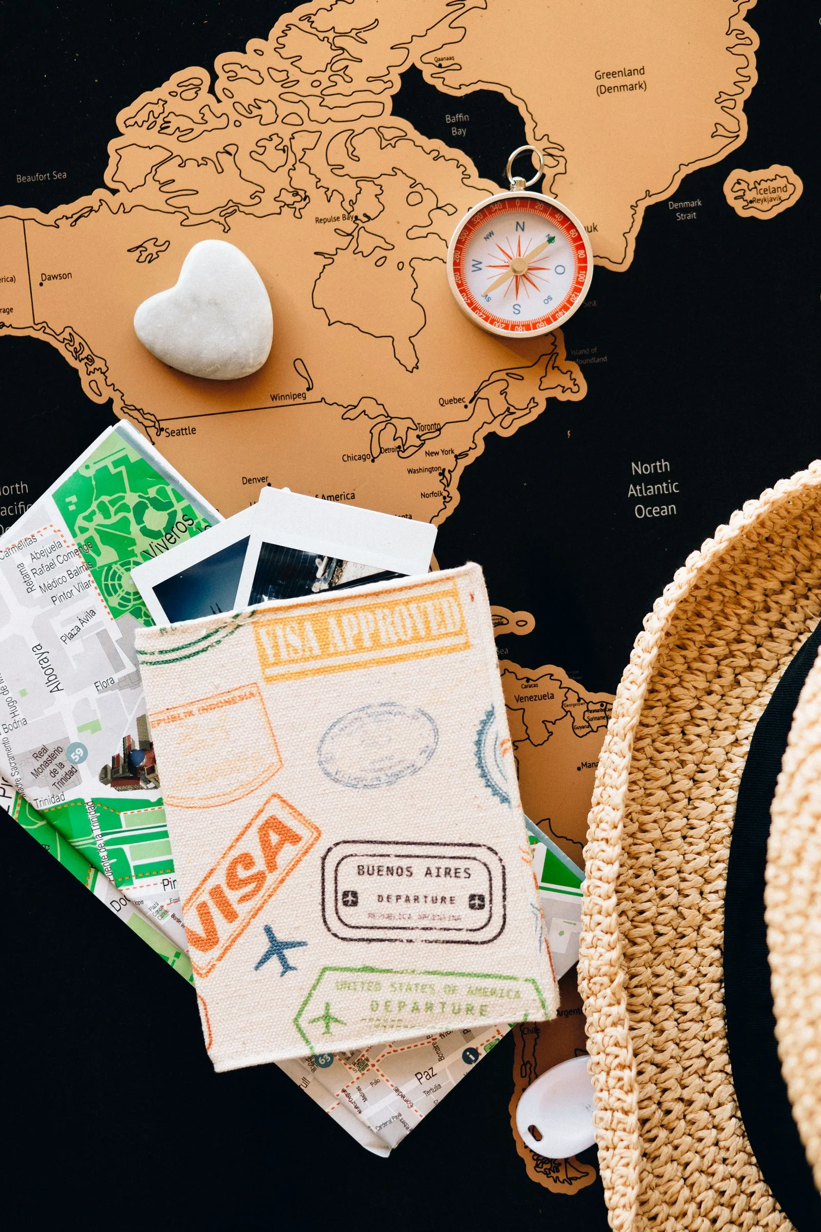 Compass and visa travel-planning materials on a world map